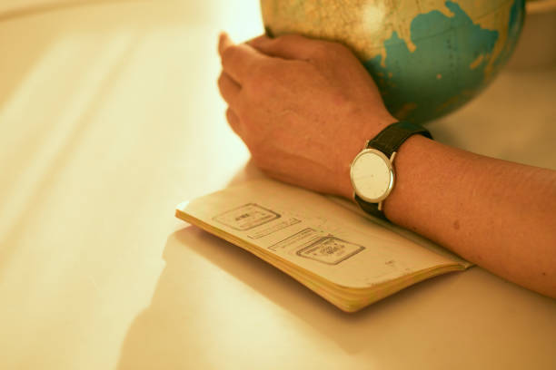 Wrist watch on the arm. Passport under the arm