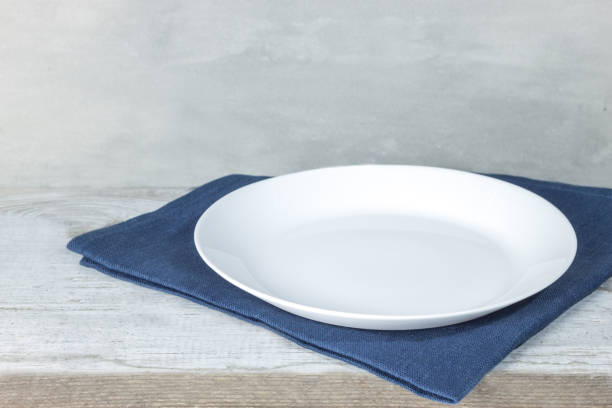 istock Empty plate on tablecloth on wooden table over grunge blue background 1092928492