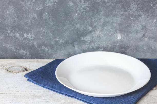 istock Empty plate on tablecloth on wooden table over grunge blue background 1092928496