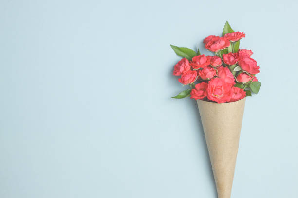 bellissimo bouquet di piccole rose rosse in carta vintage sul tavolo. - cream horn foto e immagini stock