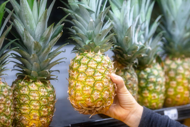 istock Shoppers hand holding a organic pineapple 1092937916