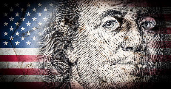 Flag of America with old grunge texture and portrait of Benjamin Franklin on one hundred dollars close up