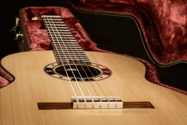 istock Acoutic guitar sits in red velvet lined case 1093002620