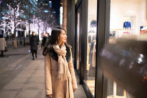 Asian woman shopping at winter night