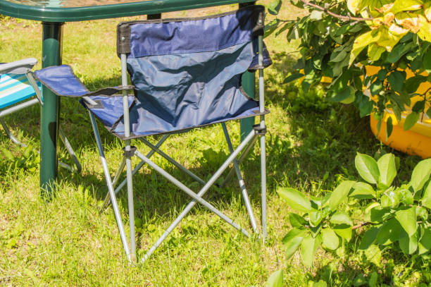istock Plastic folding table and folding chairs for camping stand on the grass on a Sunny summer day 1093043958