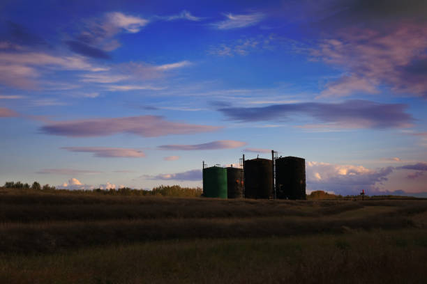 Silhouette of bitumen tanks under a sunset Silhouette of bitumen tanks under a purple blue sunset oilsands stock pictures, royalty-free photos & images