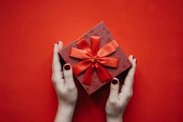 istock The girl is holding a red box with a gift. 1093067916