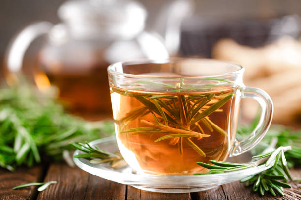 rosmarin-tee im glas teetasse auf rustikalen holztisch closeup. pflanzliche vitamin tee. - homewares rustic herbal tea herb stock-fotos und bilder