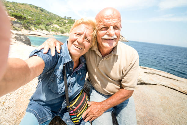 istock Senior couple vacationer taking selfie while having genuine fun at Giglio Island - Excursion tour in seaside scenario - Active elderly and travel concept around the world on warm bright sunny filter 1093084336