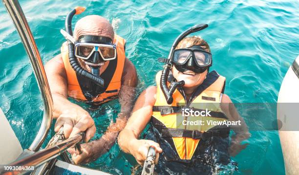 Retired Couple Taking Happy Selfie In Tropical Sea Excursion With Life Vests And Snorkel Masks Boat Trip Snorkeling In Exotic Scenarios On Active Elderly And Senior Travel Concept Around World Stock Photo - Download Image Now