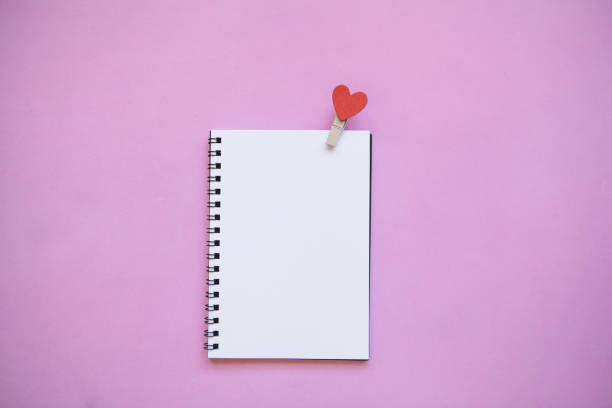 istock Blank notepad with pin with a heart on a pink background. 1093086490