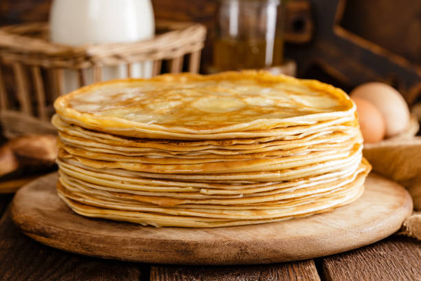 Homemade thin crepes with honey, pancakes on wooden rustic background Homemade thin crepes with honey, pancakes on wooden rustic background crêpe pancake stock pictures, royalty-free photos & images