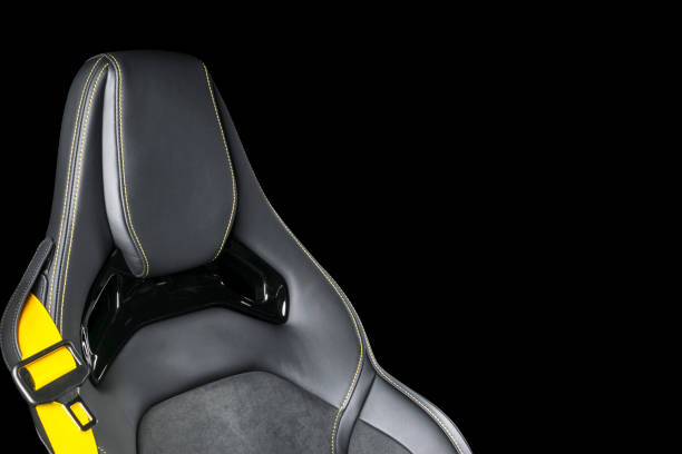 istock Black leather interior of a car. Perforated Leather comfortable seats with yellow stitching isolated on black background. Car interior details. Car detailing. Car inside 1093093568
