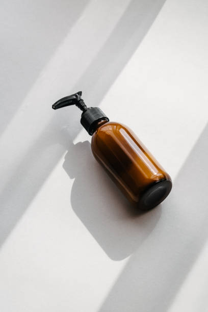 pump dispenser cosmetic glass brown bottle - merchandise luxury still life spa treatment imagens e fotografias de stock