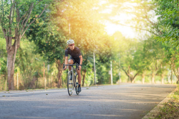 Young man Cyclist riding mountain bike in public park at morning Young man Cyclist riding mountain bike in public park at morning cycling vest photos stock pictures, royalty-free photos & images