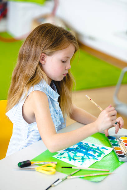 istock Girl Painting On Paper At Table 1093102246