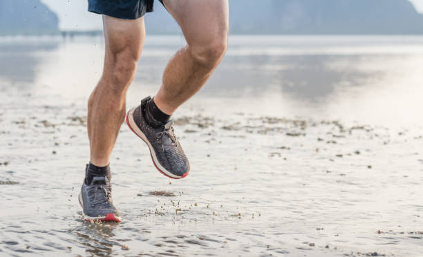 istock Young asian man running on beach with sunset in background 1093108240