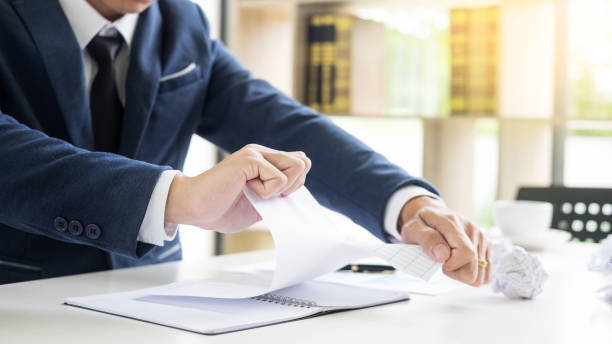 istock Midsection Of Businessman Tearing Paper On Table 1093116748