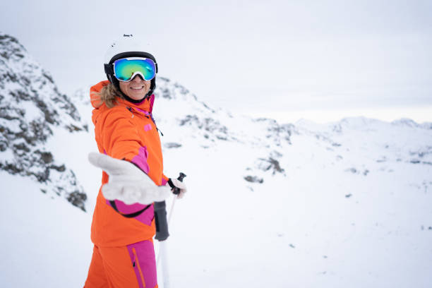istock smiling skiing woman holding out a helping hand 1093118346