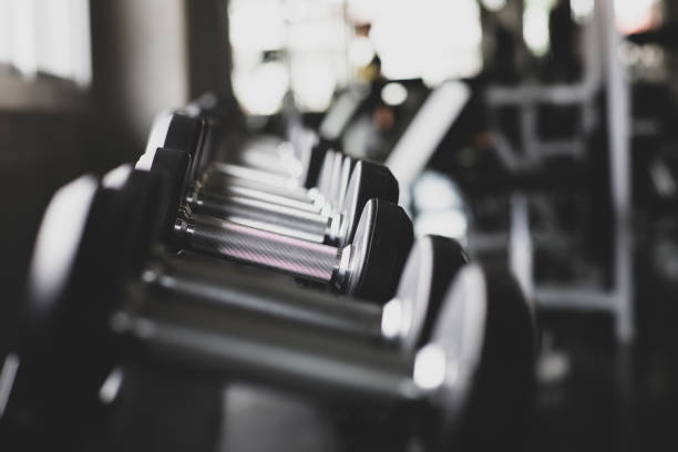 istock Dumbbells on rack, with different weight, macro shoot and very detailed on lifting handle, Standard equipment in all gym. 1093125628