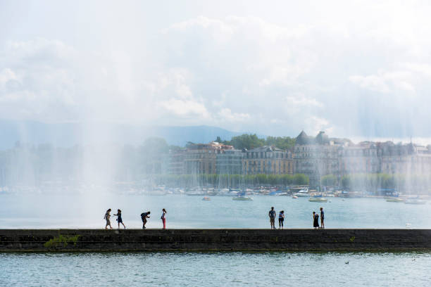 les gens sont promènent sous le jet d’eau à genève, suisse - lake geneva photos et images de collection