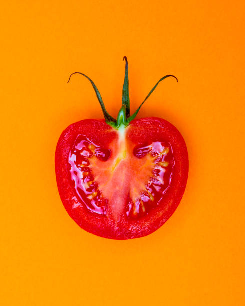 istock Single Half Salad Tomato with stalk pop Art style centred from above on bright  Orange coloured background 1093139522