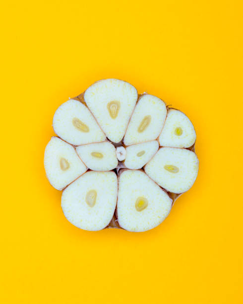 istock Half Garlic Bulb pop Art style centred from above on bright Yellow coloured  background 1093142378