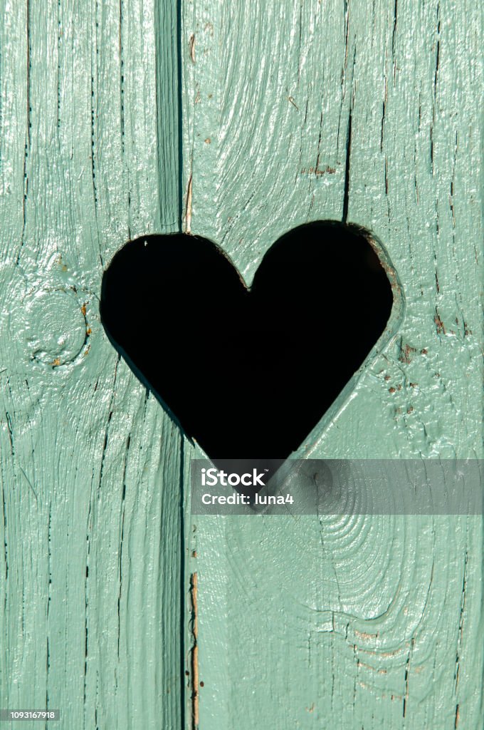 heart in a wooden door heart in a green wooden door Outhouse Stock Photo