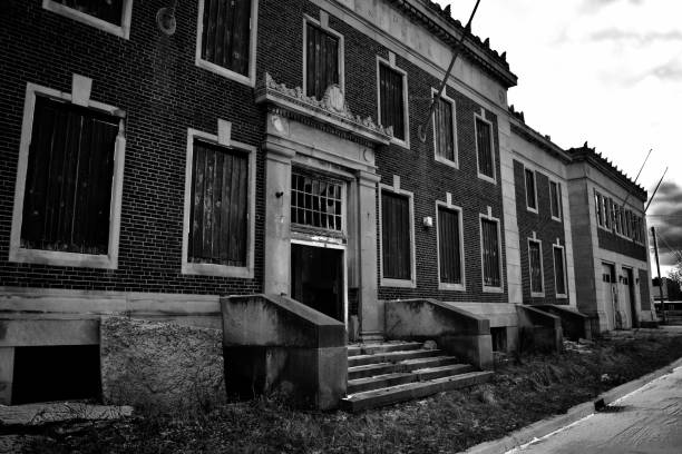 Old firehouse Brick firehouse in monochrome in Highland Park, Michigan from the street, empty and abandoned, with a cloudy sky during day. highland park michigan stock pictures, royalty-free photos & images