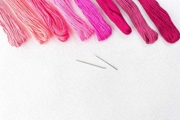 istock Flat lay top view with an embroidery canvas, needles, threads in red colours 1093174822