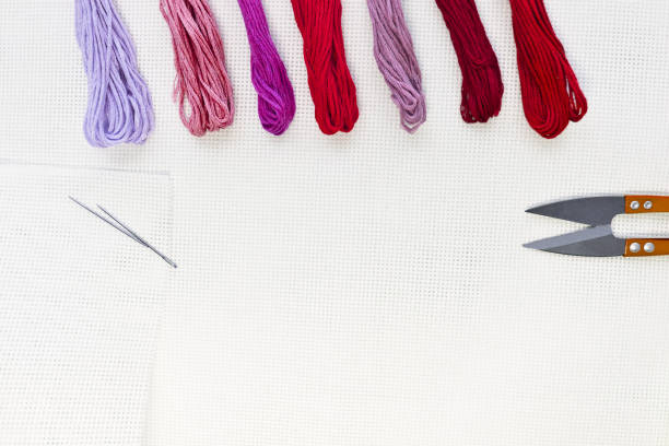 istock Flat lay top view with an embroidery canvas, needles, threads in red colours 1093174874