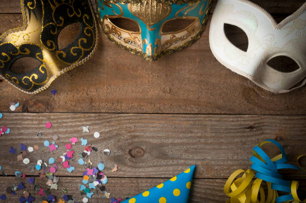 Carnival masks on wooden table with streamers and confetti Mardi gras masks on wooden table with streamers and confetti streamer photos stock pictures, royalty-free photos & images