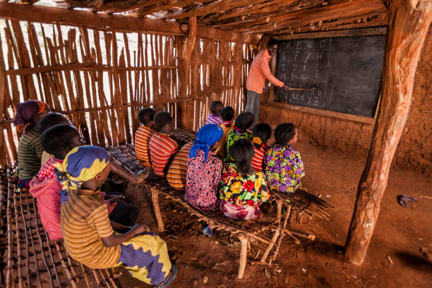 African children during english class, southern Ethiopia, East Africa African children during english class in very remote school. The bricks that make up the walls of the school are made of clay and straw. There is no light and electricity inside the classroom ethiopia photos stock pictures, royalty-free photos & images