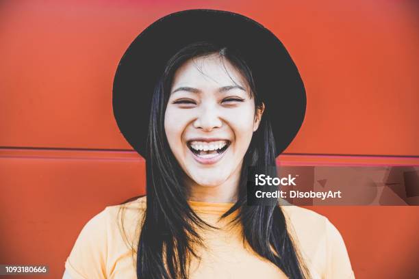 Portrait Of Happy Asian Girl Smiling With Coral Background Young Chinese Woman Having Fun Posing In Front Of The Camera Fashion Casual Clothes And Millennial Generation Concept Focus On Face Stock Photo - Download Image Now