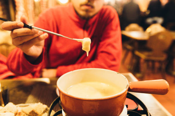 istock Man eats fondue over Christmas in Switzerland 1093192492