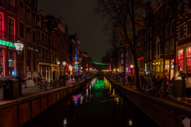 Canal and street at Famous Red light District city nightlife in Amsterdam. stock photo