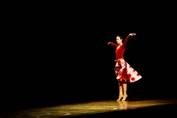 istock Woman dancing ballet on a empty stage against black background 1093201950