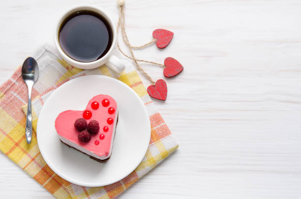 souffle cake in the form of heart  with cup of coffee on a wooden table stock photo