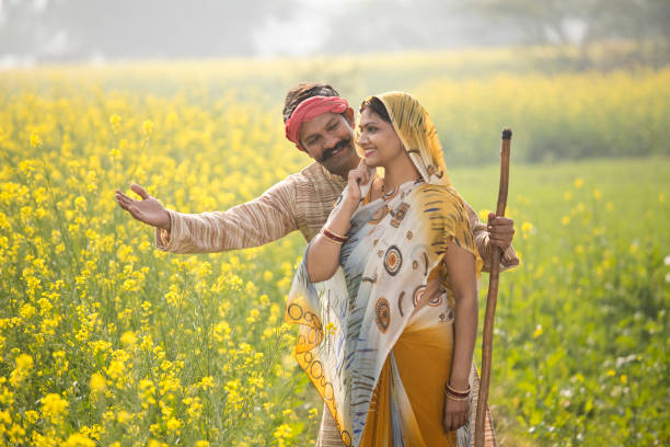 istock Rural indian couple standing in rapeseed field 1093204488