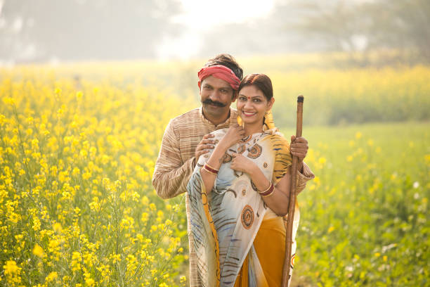 istock Rural indian couple standing in rapeseed field 1093204888