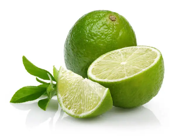 Whole and slice of lime with leaves isolated on white background