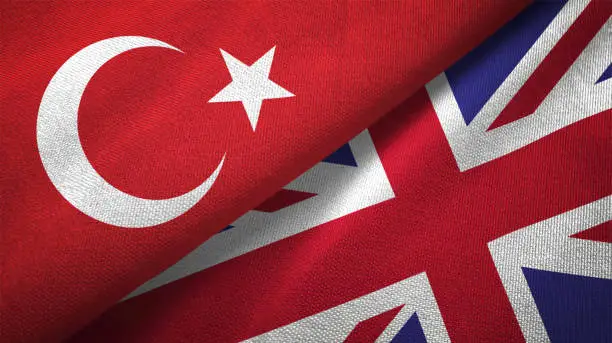 Photo of United Kingdom and Turkey two flags together textile cloth fabric texture