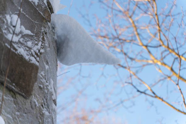 the icicle on the concrete wall is covered with snow with a blurred background. abstract winter background