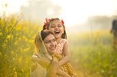 Mother with daughter having fun at agriculture field