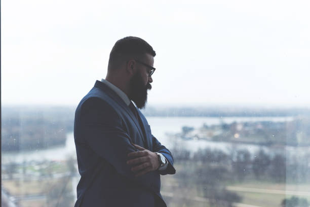 istock Pensive businessman looking through window 1093222340