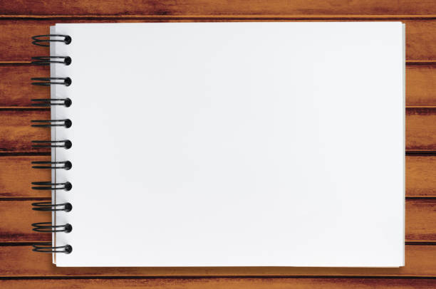 istock Blank notebook page on top of wood office desk table. Top view, flat lay. 1093223112