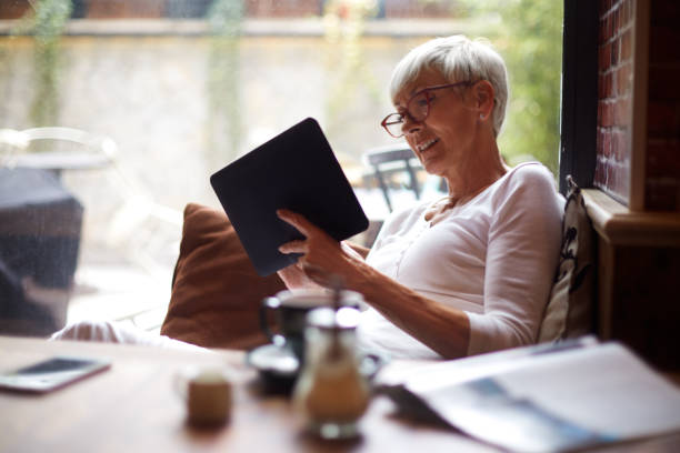 istock Elderly woman using a digital tablet while sitting comfortably in a cafeteria 1093223550