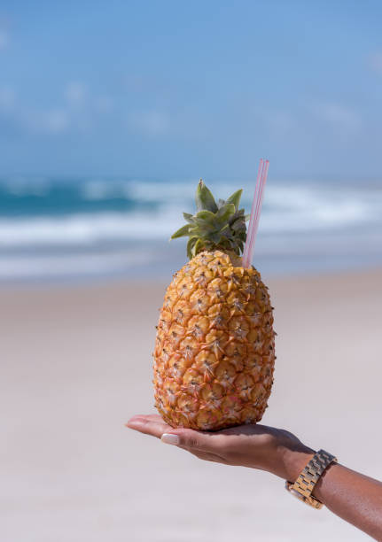 istock Female hand holding pineapple cocktail 1093229908