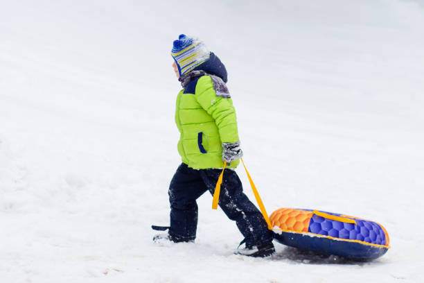 istock Childhood winter sport. Child rolls down from snow mountain 1093230478