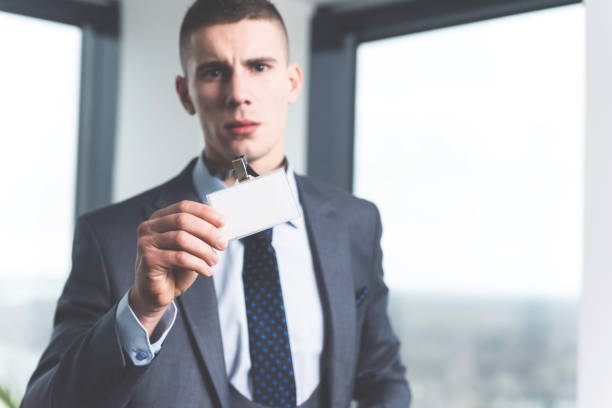 Young businessman showing ID card